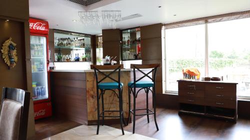 un bar con dos taburetes en un mostrador en una habitación en GOLDEN LEAF RESORT en Surajgarha