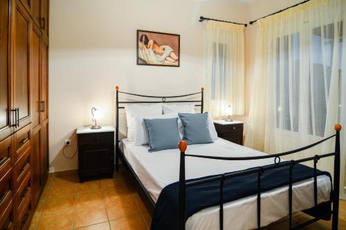 a bedroom with a bed with blue pillows at The Antique House in Batsi