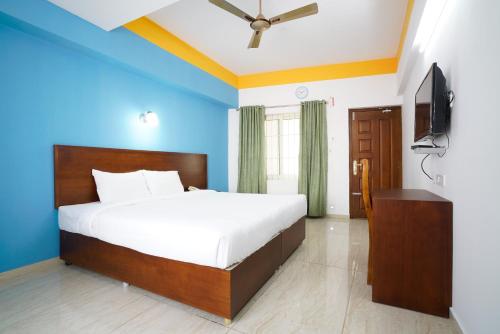 a bedroom with a bed and a flat screen tv at Hotel Signature Cochin in Cochin