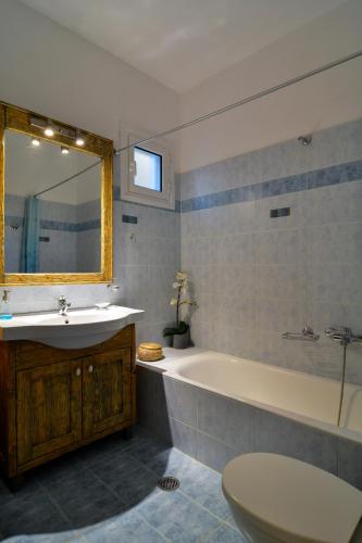 a bathroom with a sink and a tub and a toilet at The Antique House in Batsi