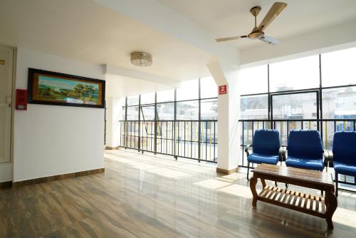 a waiting room with blue chairs and a wall of windows at Hotel Signature Cochin in Cochin