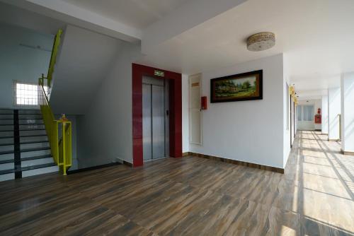 a hallway with white walls and wooden floors at Hotel Signature Cochin in Cochin