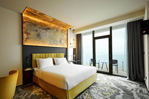 a hotel room with a bed and a large window at Miramare Magnetic Beach Hotel in K'obulet'i