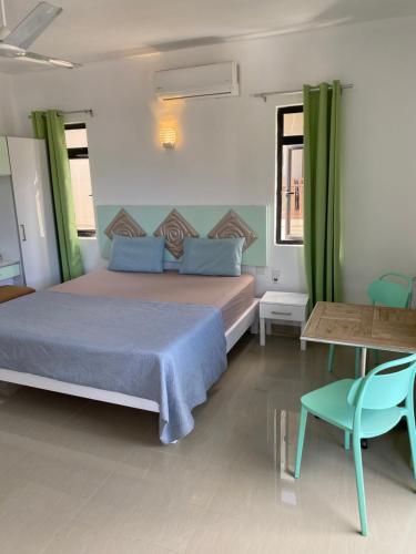 a bedroom with a bed and a table and chairs at Residence La Colombe in Grand Baie