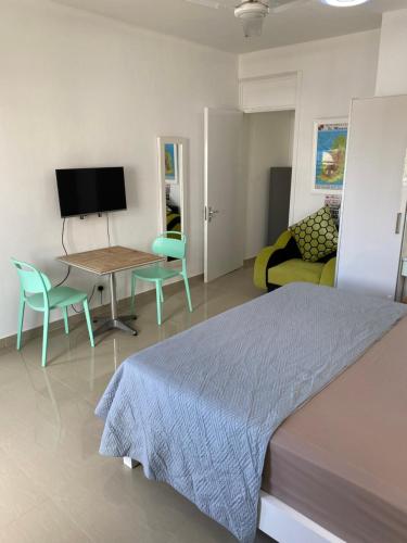 a bedroom with a bed and a table and a couch at Residence La Colombe in Grand Baie
