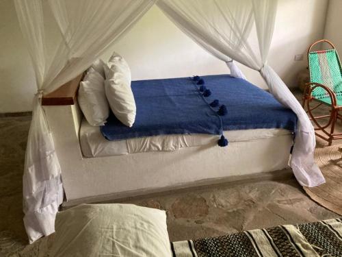 um quarto com uma cama de dossel em Lemara Eco Camp em Kisaki