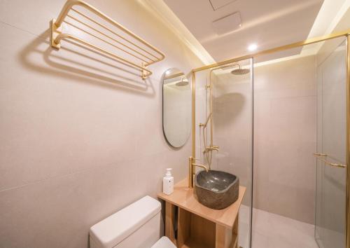 uma casa de banho com um chuveiro, um WC e um lavatório. em UH Suite Gyeongju em Gyeongju