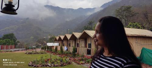 a woman looking out of a window at a building at The Jungle Mist Resort in Rishīkesh