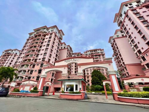 un gran edificio de apartamentos de color rosa con una puerta en la parte delantera en MARINA COURT VACATION HOME 3 BEDROOMS - Kota Kinabalu, en Kota Kinabalu