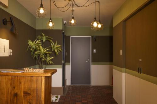 einen Flur mit grünen Wänden, Tür und Licht in der Unterkunft 自由自在OSU 501(SORA) in Nagoya