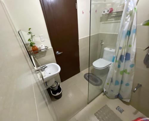 a bathroom with a shower and a sink and a toilet at JCM- Studio Deluxe Room in Manila