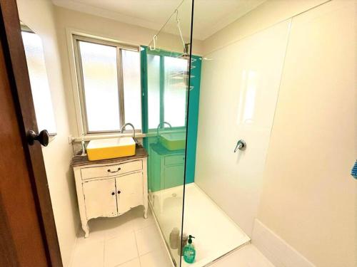 La salle de bains est pourvue d'une douche en verre et d'un lavabo. dans l'établissement Beachfront Holiday Home, à Apollo Bay