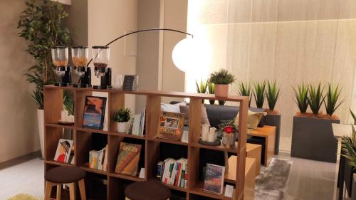 a book shelf filled with books in a room with plants at Sakura Garden Hotel in Osaka