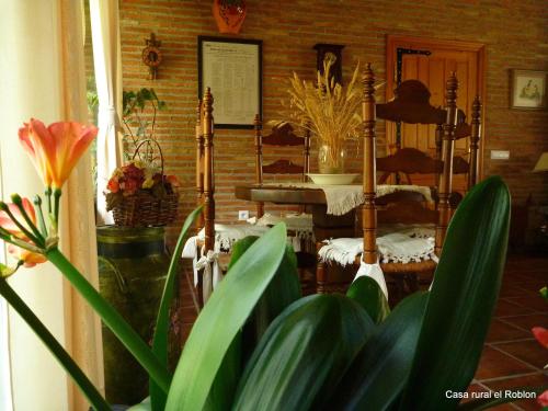 a room with a table and a plant in the foreground at Casa Rural El Roblon in Sartajada
