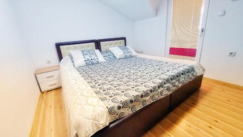 een slaapkamer met een groot bed met kussens erop bij The Sunshine apartment in Prilep