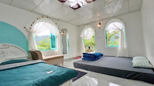 1 dormitorio con 2 camas, sofá y ventanas en Estrella Ba Vì Villas - Venuestay, en Ba Vì