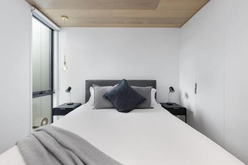 a bedroom with a white bed and a window at Park Place Luxe - Stylish & Central Apartment in Ocean Grove