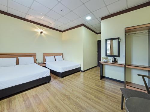 Capital O 90761 D Jiwa Hotel في Pendang: غرفة فندقية بسريرين وطاولة