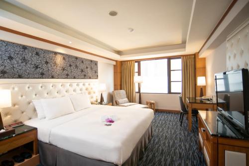 a hotel room with a large bed and a television at Hotel Dion in Taichung