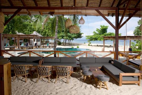 un complexe avec une piscine et une plage dans l'établissement Metita Beach & Dive Resort, à Doruba