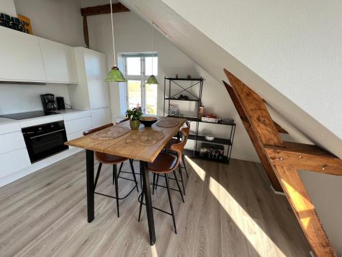 a kitchen with a wooden table and some chairs at Hygge Loft in Varde