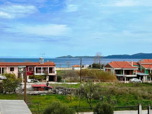 a view of a town with houses and the water at Nea Roda Apartments in Nea Roda