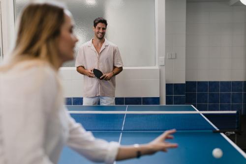a man and woman playing a game of table tennis at Pier 21 Riverside Apartment Hotel in Fremantle
