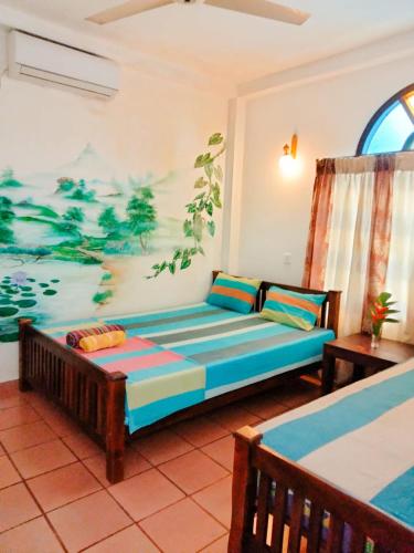 ゴールにあるBackpacker Galle Hostelのソファと壁に絵が飾られたリビングルーム