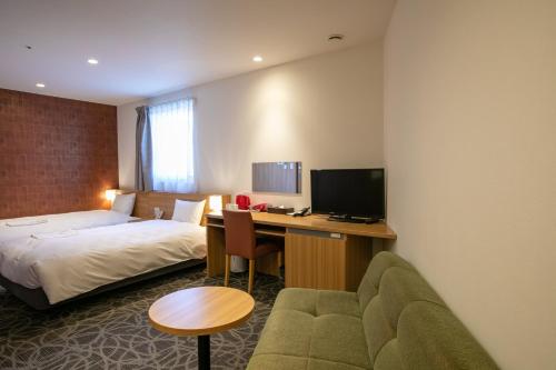 ein Hotelzimmer mit einem Bett und einem Schreibtisch in der Unterkunft Sakura Garden Hotel in Osaka
