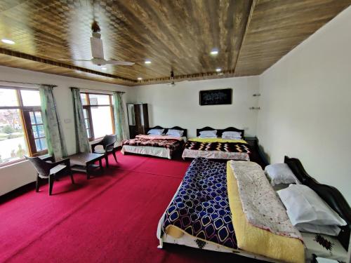 - une chambre avec 2 lits et un tapis rouge dans l'établissement Kashmir Homestay, à Gulmarg