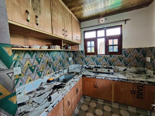 stara kuchnia z uszkodzonym blatem w obiekcie Kashmir Homestay w mieście Gulmarg