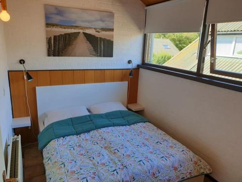 a bedroom with a bed in a room with a window at Welkom in DeKreek V59, dem freundlichen Ferienhaus in Bruinisse