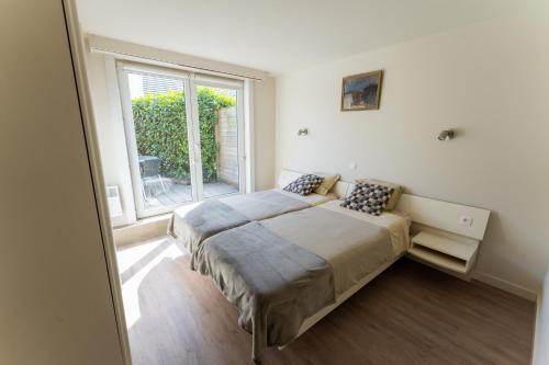 um quarto com 2 camas em frente a uma janela em B&B Lanterfanters' em Nieuwpoort