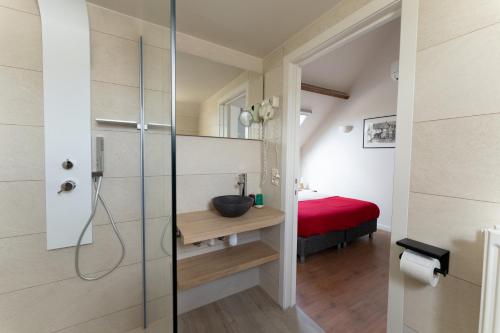 ニーウポールトにあるB&B Lanterfanters'のバスルーム(シャワー付)、赤いベッド1台が備わります。