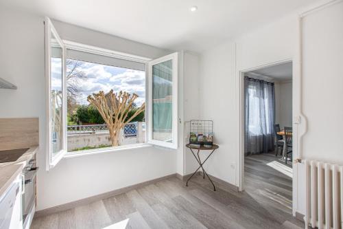 Il comprend une cuisine aux murs blancs et une grande fenêtre. dans l'établissement Happy - Charmante maison de plain-pied, à Noyers-sur-Cher