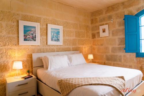 a bedroom with a bed and two pictures on the wall at Authentic Country Home with Incredible Outdoor Area in Xagħra