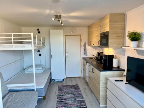 a small room with a bunk bed and a kitchen at Holiday Apartment Köpingsvik in Köpingsvik