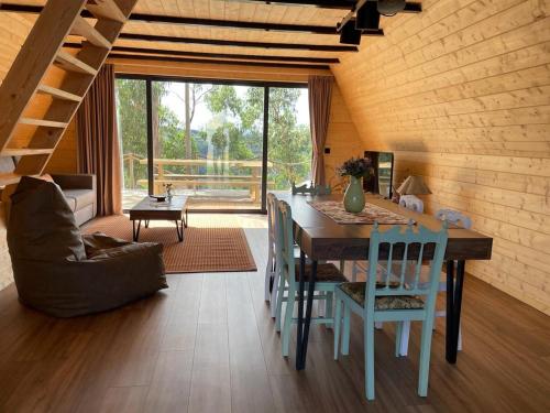 a dining room with a table and chairs in a room at Medronho D'Ouro bungalows in Foz do Sousa