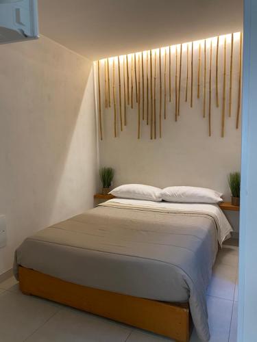 トラーパニにあるMarta House 2のベッドサイドシックス付きの壁のある客室のベッド1台分です。