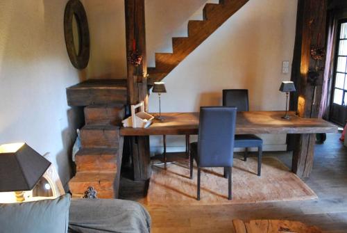 - une table et des chaises en bois dans une chambre avec un escalier dans l'établissement Paradis perdu en Sologne avec plage privée, à Villeny