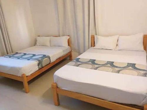 two twin beds in a room withthritisthritislictslictslicts at Le Kato Lux Rodrigues in Rodrigues Island