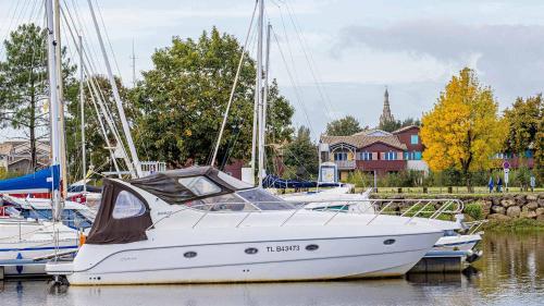 a white boat is docked in the water at Madame Vacances Les Rives Marines in Le Teich