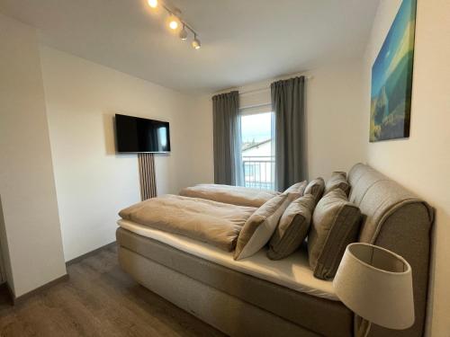 een slaapkamer met een bed, een bank en een raam bij Luxuriöse Wohnung Zentral mit großem Balkon in Losheim