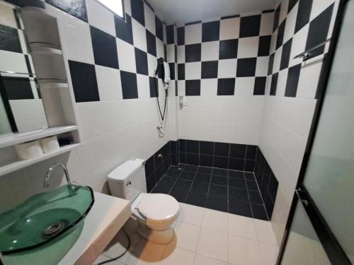 a bathroom with a black and white checkered wall at Baan Long Beach in Ko Lanta