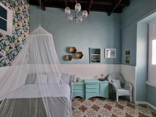 a bedroom with a bed with a canopy and a chair at Cool Canaria in Agaete