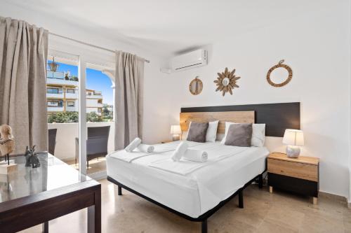 ein Schlafzimmer mit einem großen weißen Bett und einem Fenster in der Unterkunft Golf course view apartment Ref 198 in Fuengirola