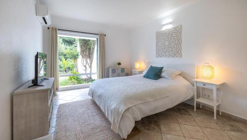 a bedroom with a bed with a television and a window at LongLands Peak at Windmill Hill in Albufeira