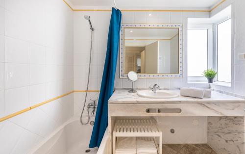a bathroom with a sink and a tub and a mirror at LongLands Peak at Windmill Hill in Albufeira