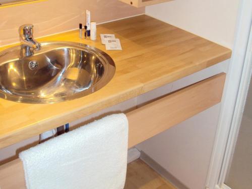 a sink in a bathroom with a wooden counter at Camping Onlycamp L'Argenté in Condom