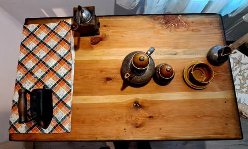 a wooden table with a tea kettle and cups on it at Dom Pracy Twórczej Macondo in Miedzno